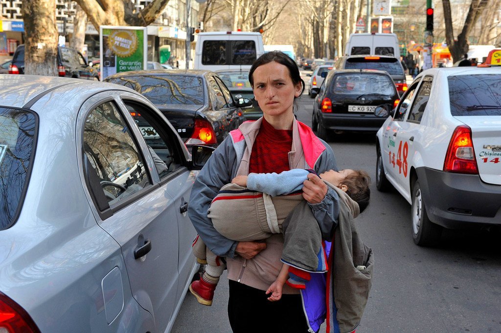 Una mujer pide dinero, mientras lleva a su hijo en brazos, en las calles de Chisinau, Moldavia.  Muchos niños en Europa del Este y Asia Central ahora viven en la pobreza.